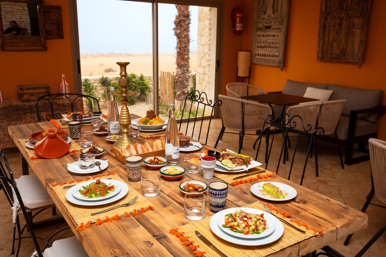 restaurant with rattan furniture orange in colour, wood on the walls, beach views